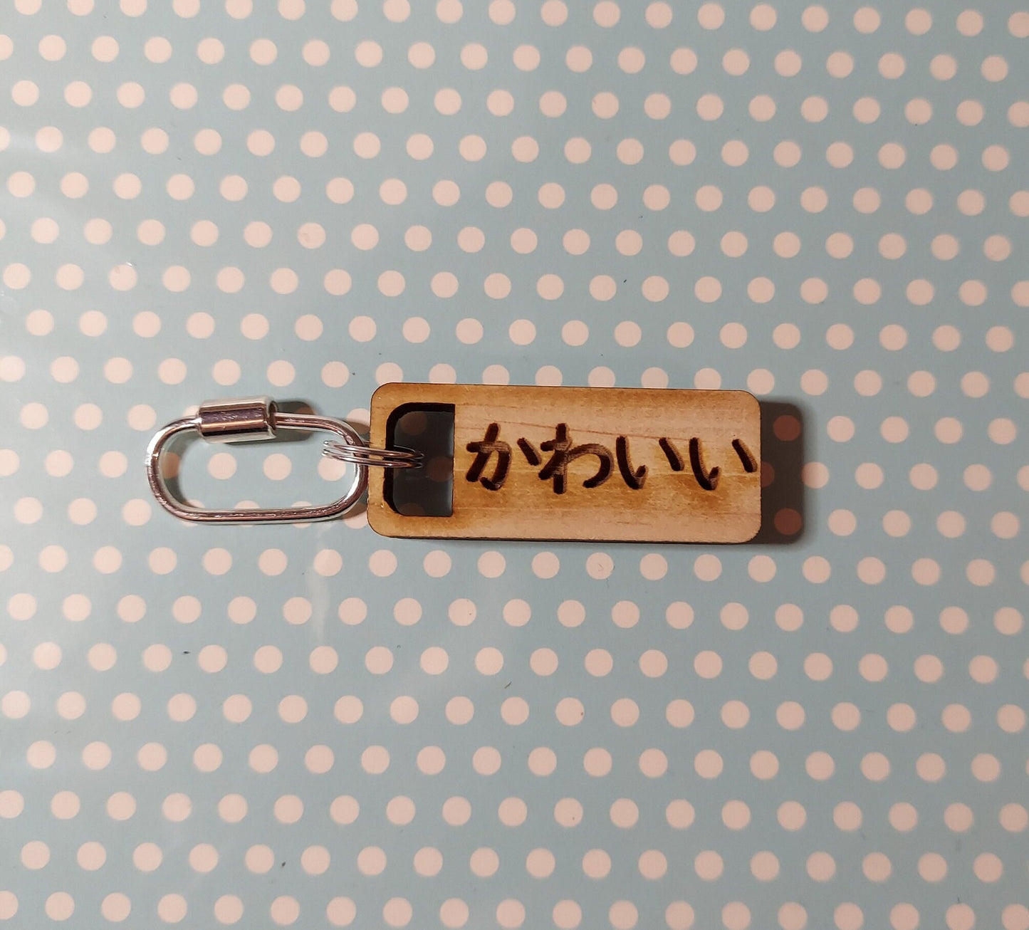 Keychain with wooden rectangle with the word &quot;Kawaii&quot; in Japanese. Metal split ring and barrel clasp o-ring.