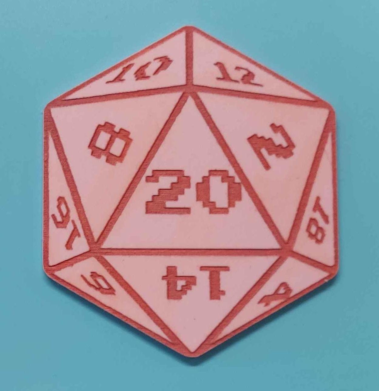 Pink acrylic coaster cut to resemble a D20 die, with darker pink acrylic paint to show off the design.